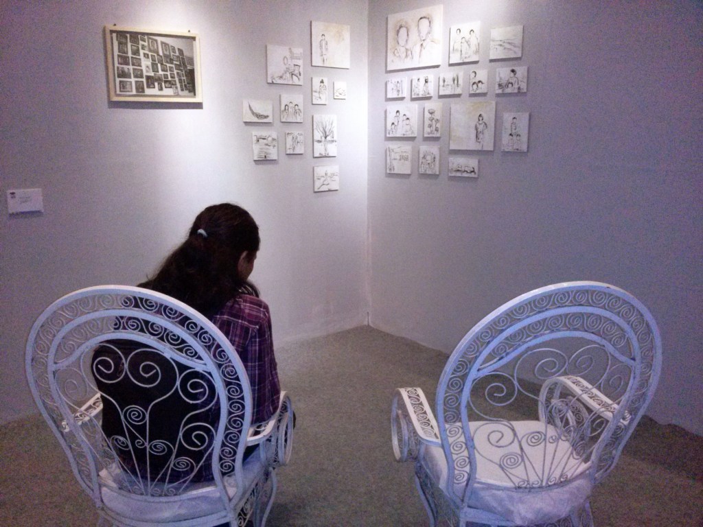 Kalau kita mundur beberapa langkah ada bangku teras jadul yang ia sediakan untuk kita duduk dan menikmati karyanya. Jadi kita serasa duduk di teras dan bernostalgia akan perjalanan hidup sebuah pasangan